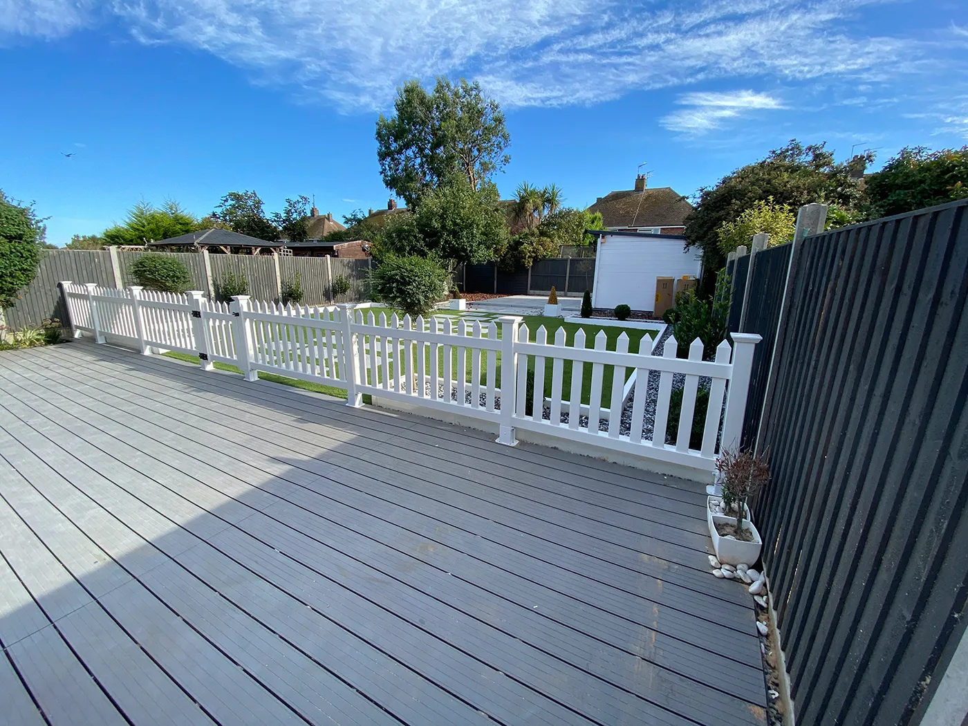 A wooden deck with a white fence around it.
