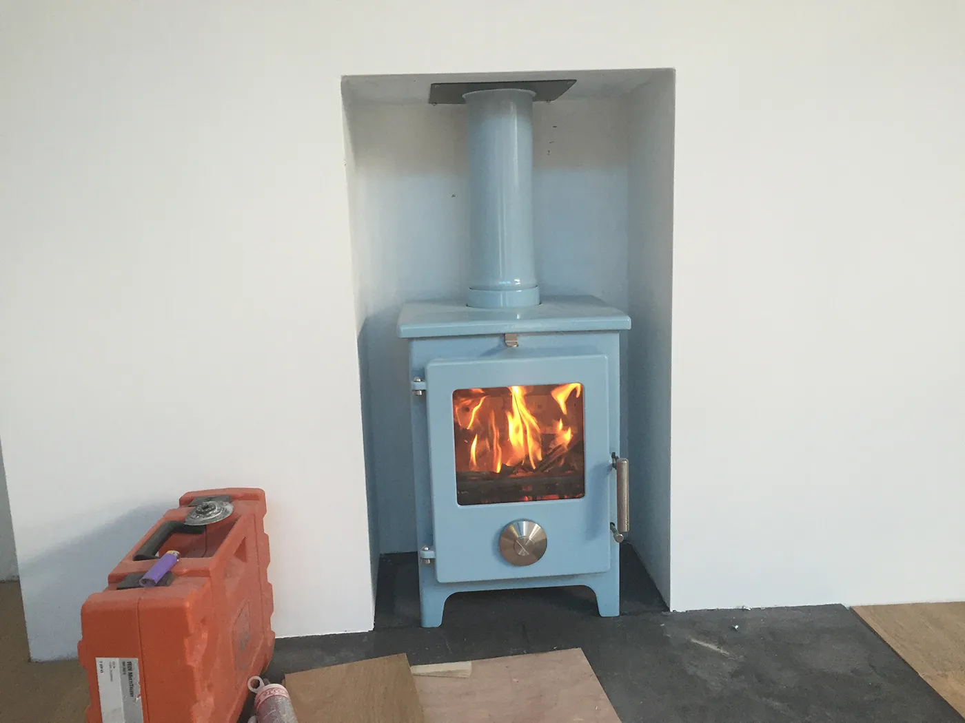 A blue stove sitting inside of a room next to a wall.